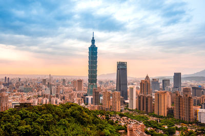 Buildings in city against cloudy sky