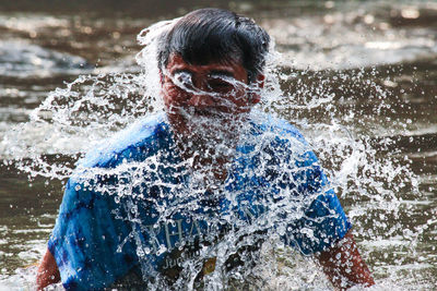 Man splashing water at river