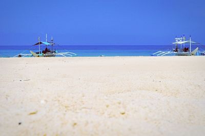 Boats in sea against clear sky