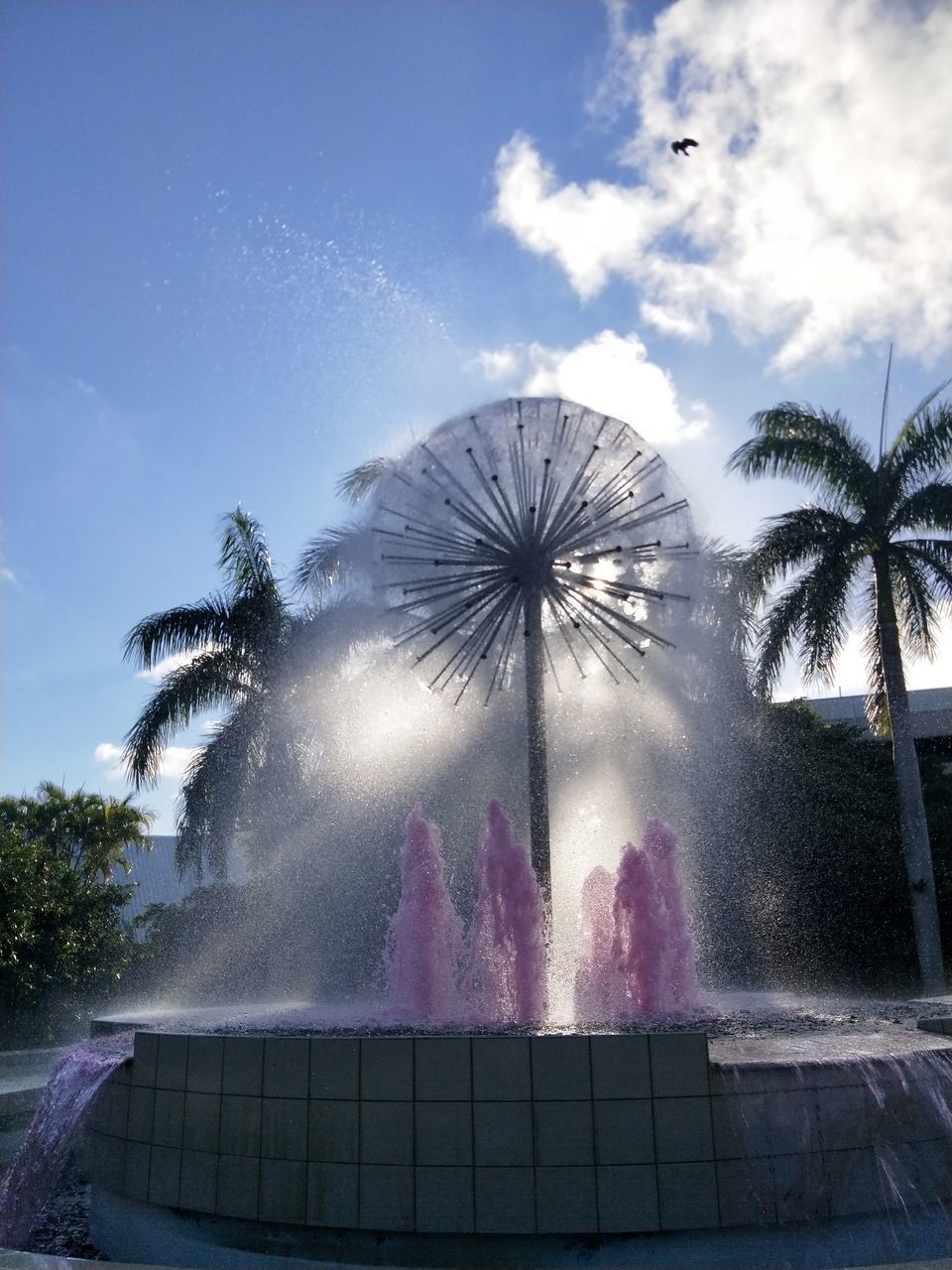 LOW ANGLE VIEW OF PALM TREES AT FOUNTAIN AGAINST SKY