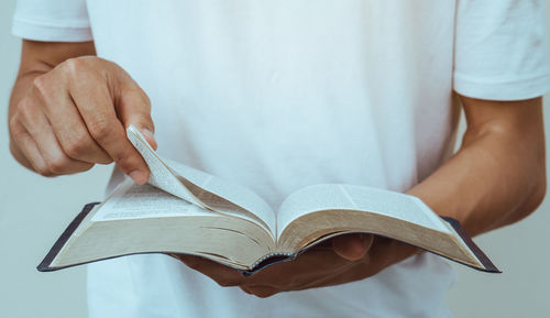 Midsection of man holding book