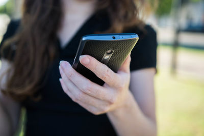 Midsection of woman using mobile phone
