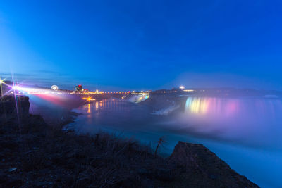 Scenic view of lake against blue sky at night