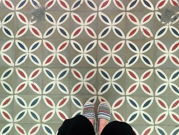 Low section of man standing on tiled floor