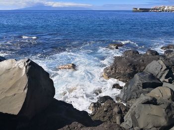 Scenic view of rocks in sea against sky