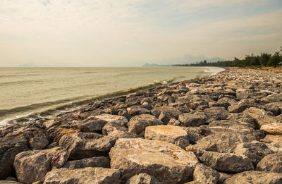 Rocks on sea shore against sky