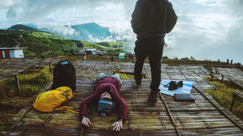 People on road by mountains against sky