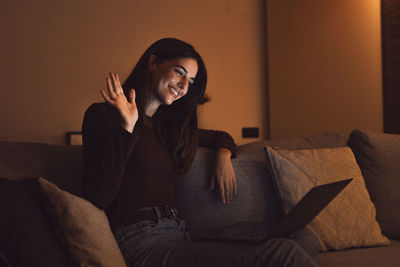 Young woman sitting on sofa at home