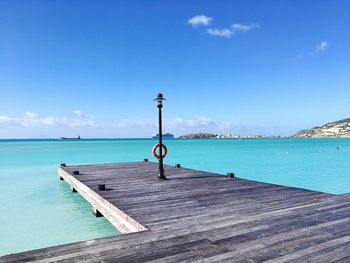 Pier over sea against blue sky