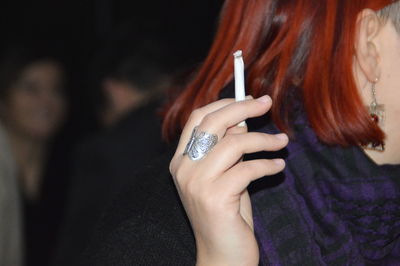 Cropped image of woman wearing ring holding cigarette