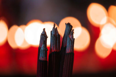 Close-up of incense sticks burning at temple during night