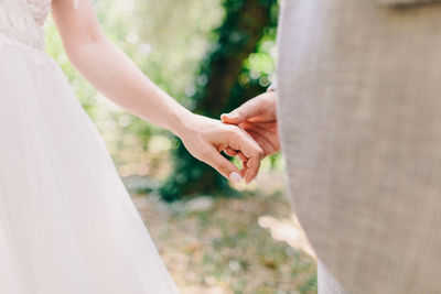 Midsection of couple holding hands