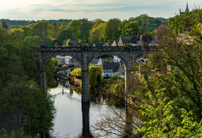 Arch bridge over river against sky