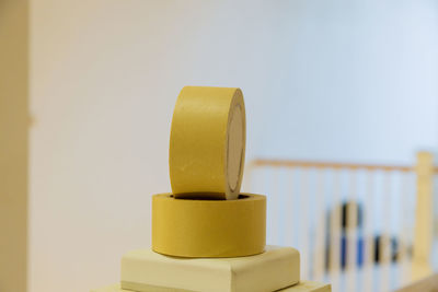 Close-up of tea light on table against wall