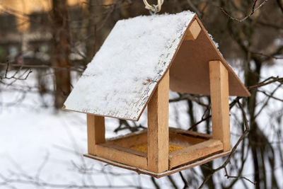 Close-up of birdhouse on snow covered field