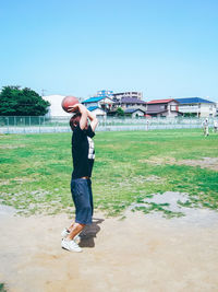 Full length of girl playing on grassy field