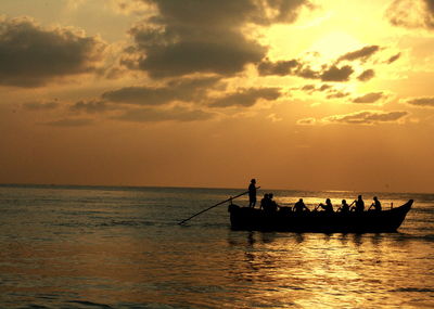 Silhouette boat sailing on sea against sky during sunset