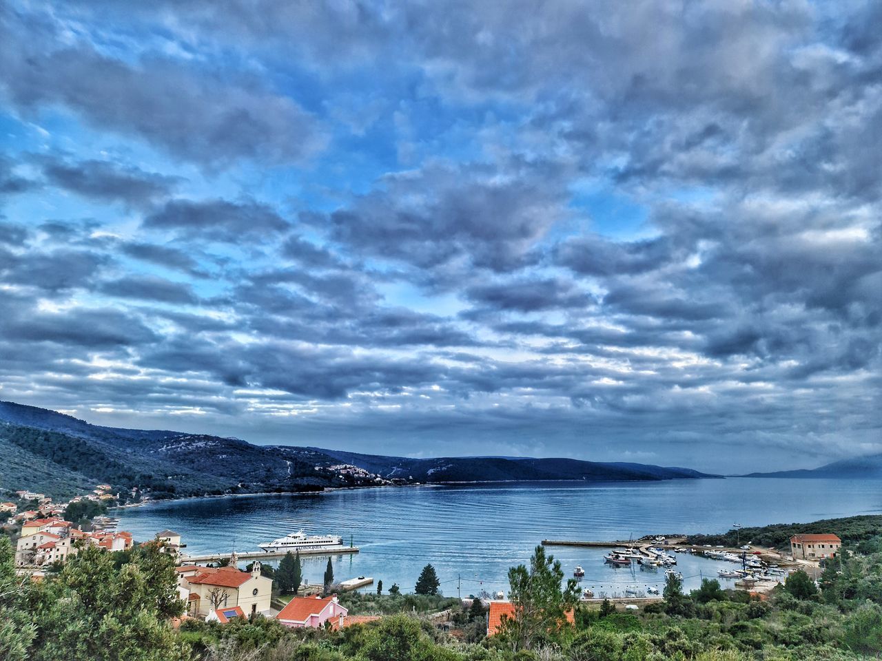 HIGH ANGLE VIEW OF TOWNSCAPE BY SEA AGAINST SKY