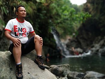 Full length of man sitting on rock