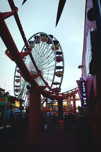 Low angle view of ferris wheel in city against sky