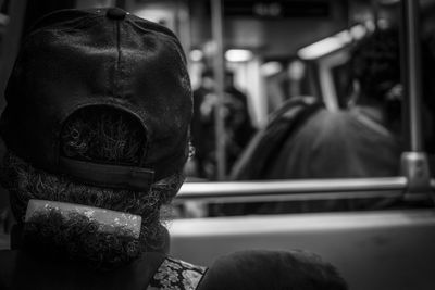 Rear view of man in metro train black and white 