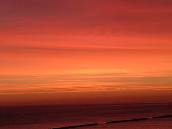 Scenic view of sea against orange sky