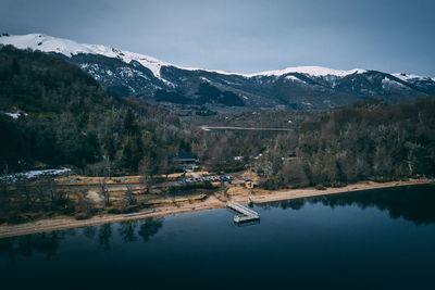 Scenic view of lake by snowcapped mountains against sky