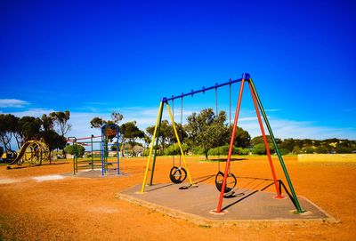 Swing at playground against blue sky