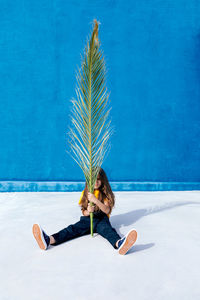 Woman with palm tree in swimming pool