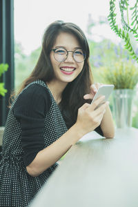 Asian younger woman laughing with happiness emotion reading smart phone