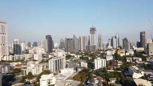 Aerial view of buildings in city against clear sky