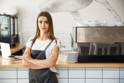 Portrait of young woman using mobile phone while sitting at home