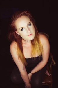 Portrait of a beautiful young woman over black background