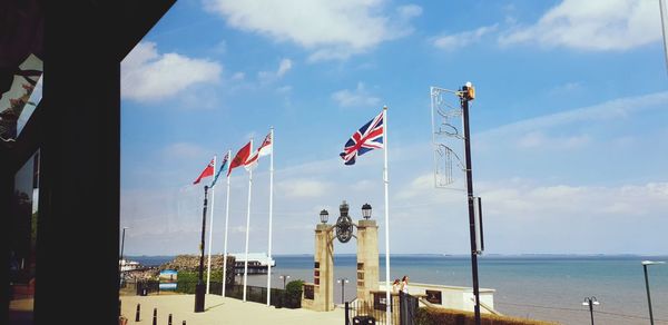 Flags on beach against sky