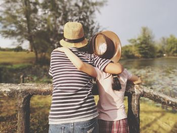 Rear view of man and woman standing against trees