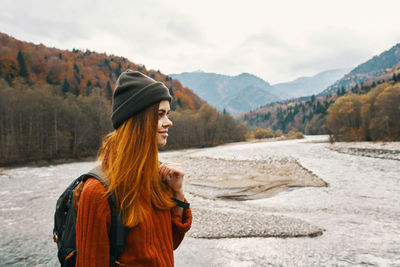 Woman with arms outstretched against mountain range