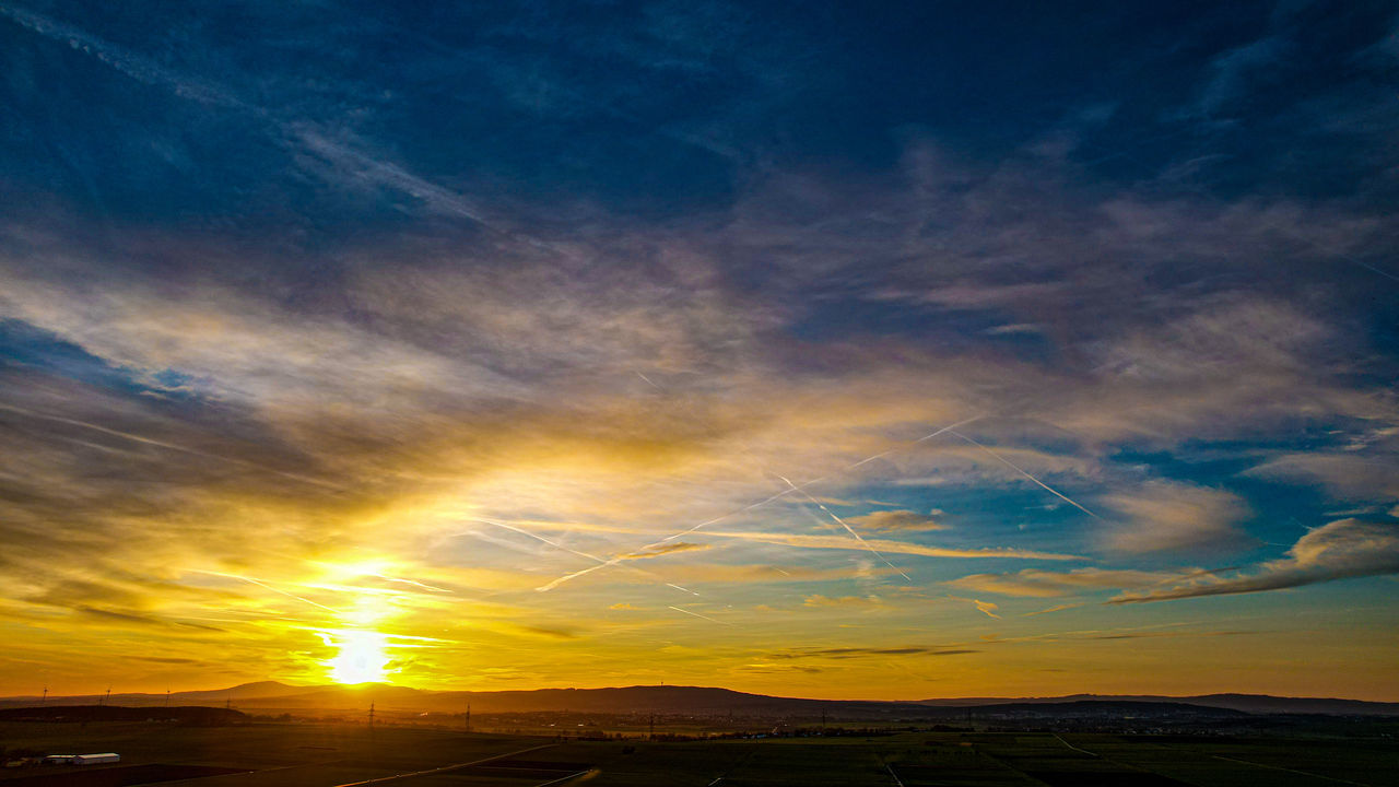 sky, cloud, sunset, horizon, afterglow, environment, beauty in nature, scenics - nature, landscape, nature, dramatic sky, dawn, sunlight, tranquility, sun, no people, evening, tranquil scene, land, horizon over land, cloudscape, sunbeam, red sky at morning, blue, outdoors, orange color, yellow, idyllic, sea, awe, travel, multi colored, non-urban scene, moody sky, travel destinations, water, silhouette, mountain, rural scene, urban skyline