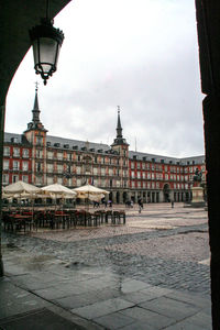 Buildings in town against cloudy sky