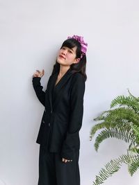 Young woman standing against wall