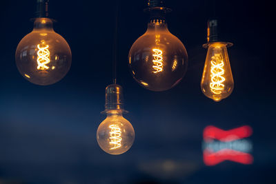 Close-up of illuminated light bulb against black background