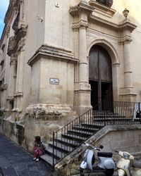 Rear view of woman walking on historic building