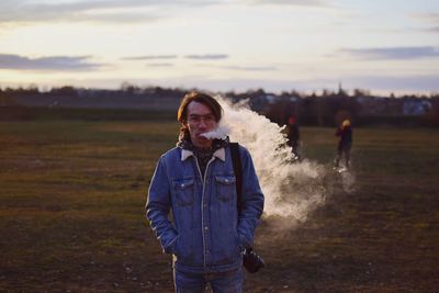 Portrait of man smoking while standing on land