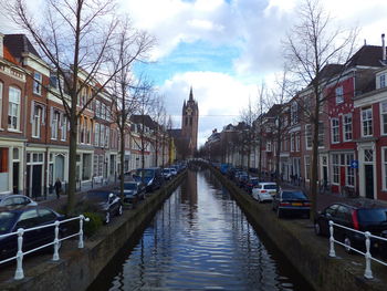 Canal amidst buildings in city against sky