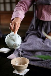 Close-up of hand serving tea