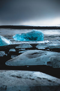 Scenic view of glacier in sea against sky