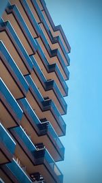 Low angle view of modern building against clear blue sky