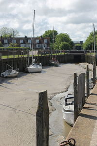 Boats moored at harbor against sky