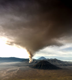Smoke emitting from bromo volcanic mountain against sky