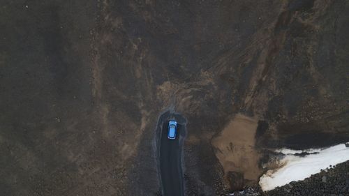 High angle view of a blue car parked in a desert.