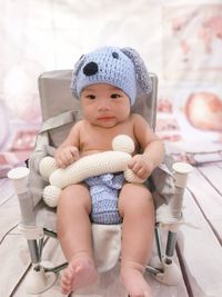 Portrait of cute baby boy sitting on floor